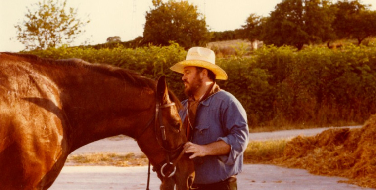 Candid family photo of opera tenor Pavarotti being nuzzled by a brown horse